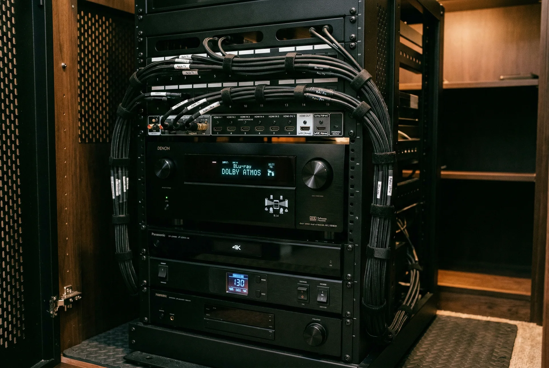 AV receiver processing Dolby Atmos signal in organized home theater equipment rack