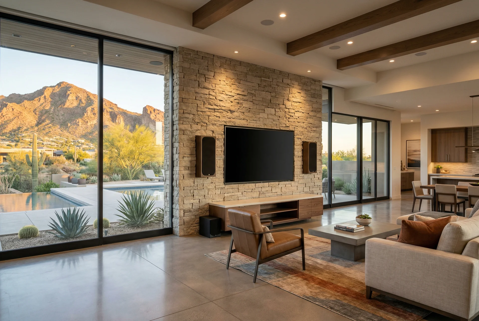 On-wall speakers flanking a TV on a stone accent wall in an open floor plan in Paradise Valley Arizona home
