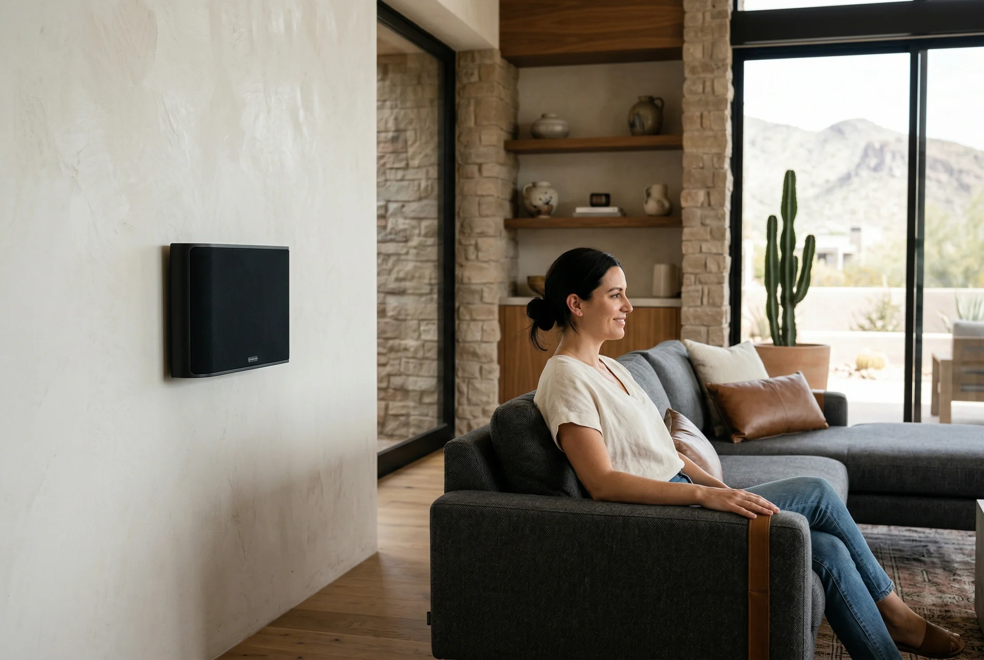On-wall surround speaker at seated ear height in Scottsdale open floor plan living room