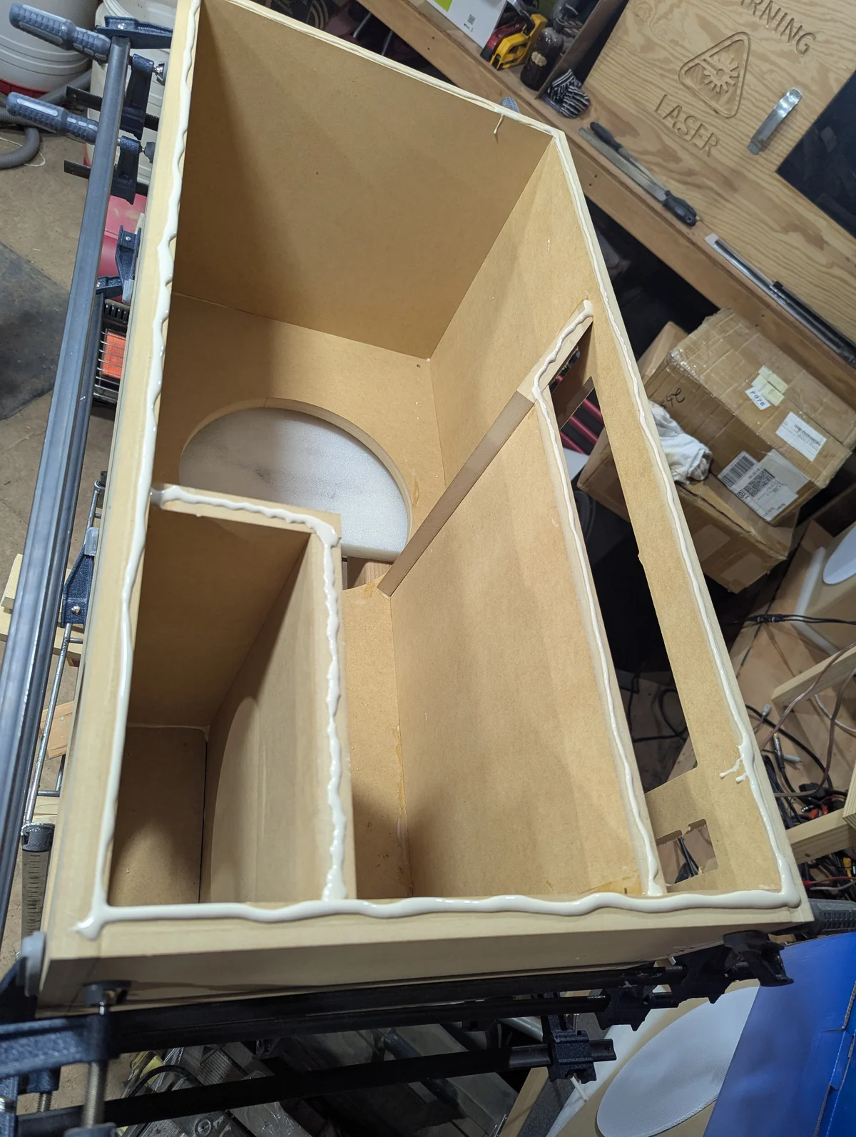 Top-down interior view of Wanstreet tower speaker cabinet showing large central dual 12-inch subwoofer chamber, separate sealed 8-inch woofer box in the front left corner, and dual amplifier housing section on the right separated by a dividing panel